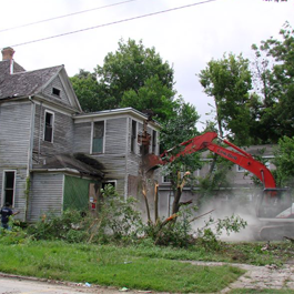 Excavator Next to an Old House